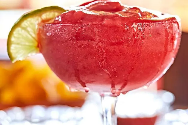 Frozen strawberry margarita with a lime wheel at Rosepepper Cantina
